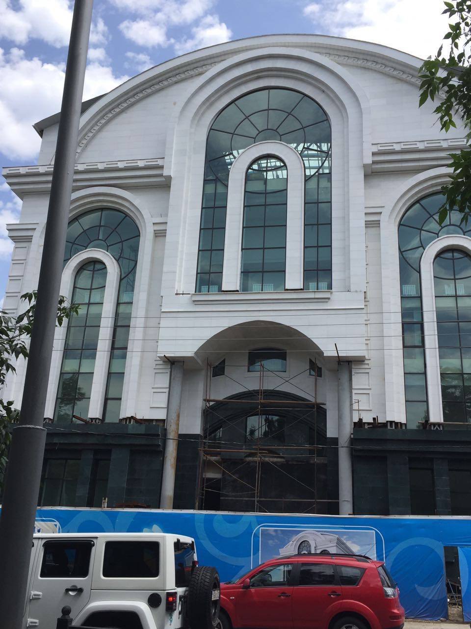 The finished facade of the restaurant in Almaty, with tall arched windows.