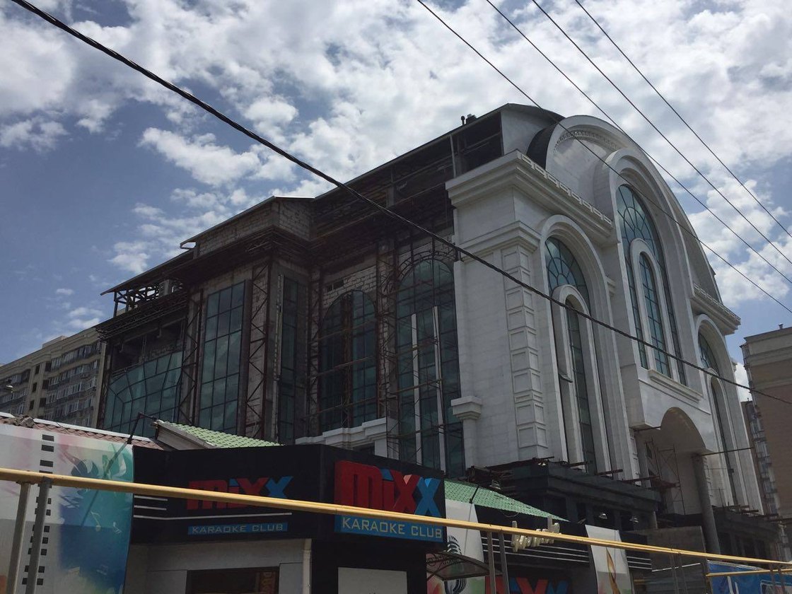 The restaurant in Almaty near completion: glazed ground floor under a classical cornice.