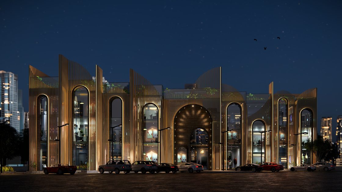 Second night view along the arcade, interior light washing through the pointed arches.