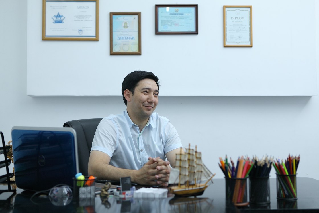 At his desk, certificates on the wall behind him